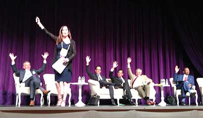 A Woman On A Stage With A Group of People SItting
